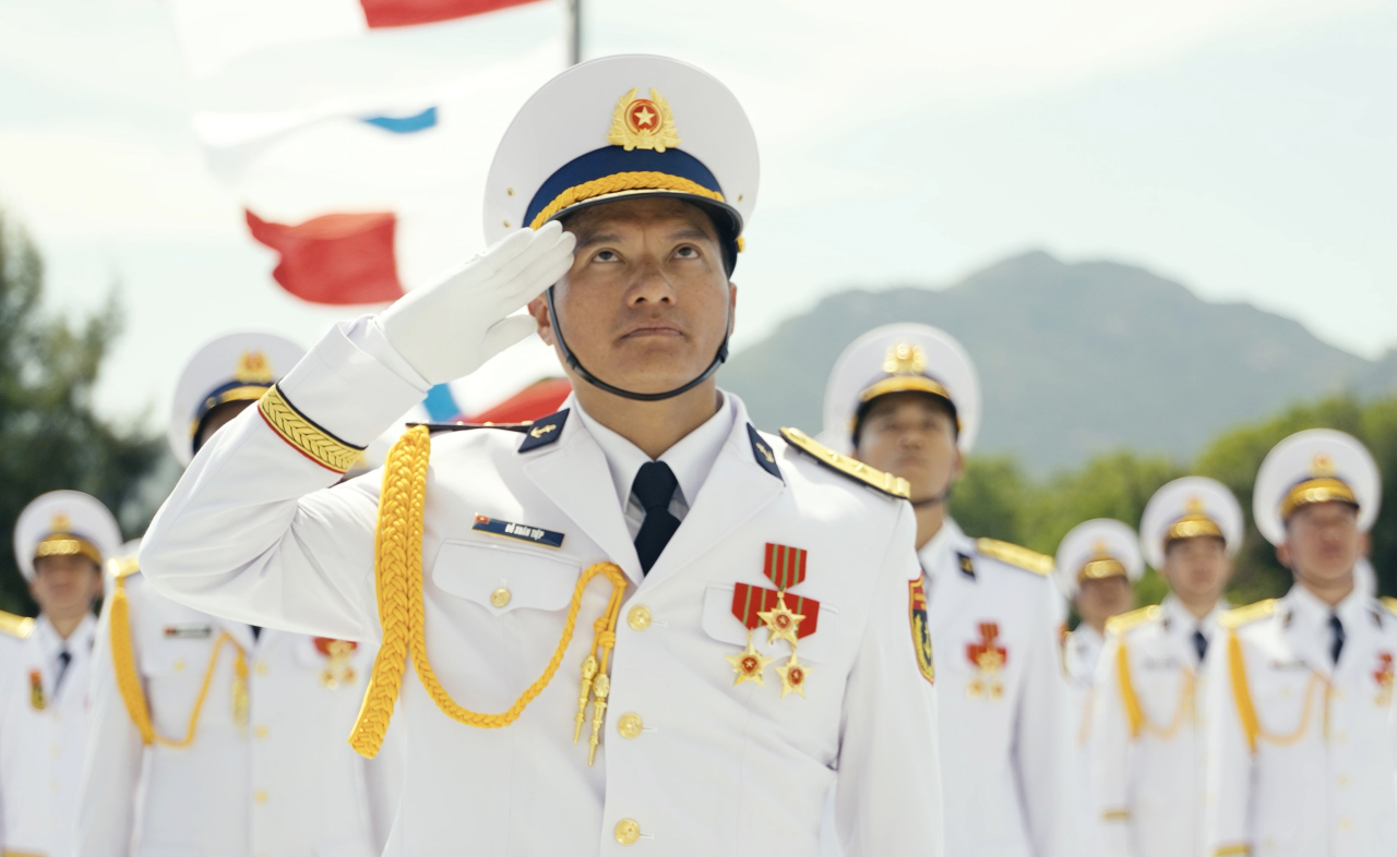 Trung tá Đỗ Xuân Tiệp, Thuyền trưởng Tàu 015-Trần Hưng Đạo (Lữ đoàn 162, Vùng 4 Hải quân), cùng đồng đội chào cờ trước khi xuất bến thực hiện nhiệm vụ diễu binh.